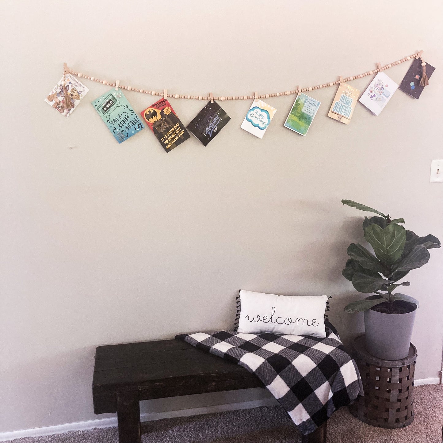 Handmade Wood bead garland display with jute twine tassels and 9 mini clothespins 6.5" total length hanging on wall displaying greeting cards