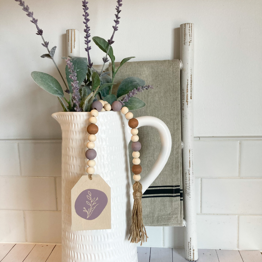 floral wood bead garland hand made from natural wood hand painted purple floral vinyl decal with wood lilac and brown beds finished with a tassel